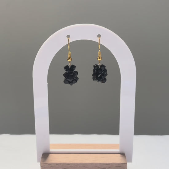 A video of the Solid Earrings Caviar dangling in the sunlight, sparkling beautifully. 